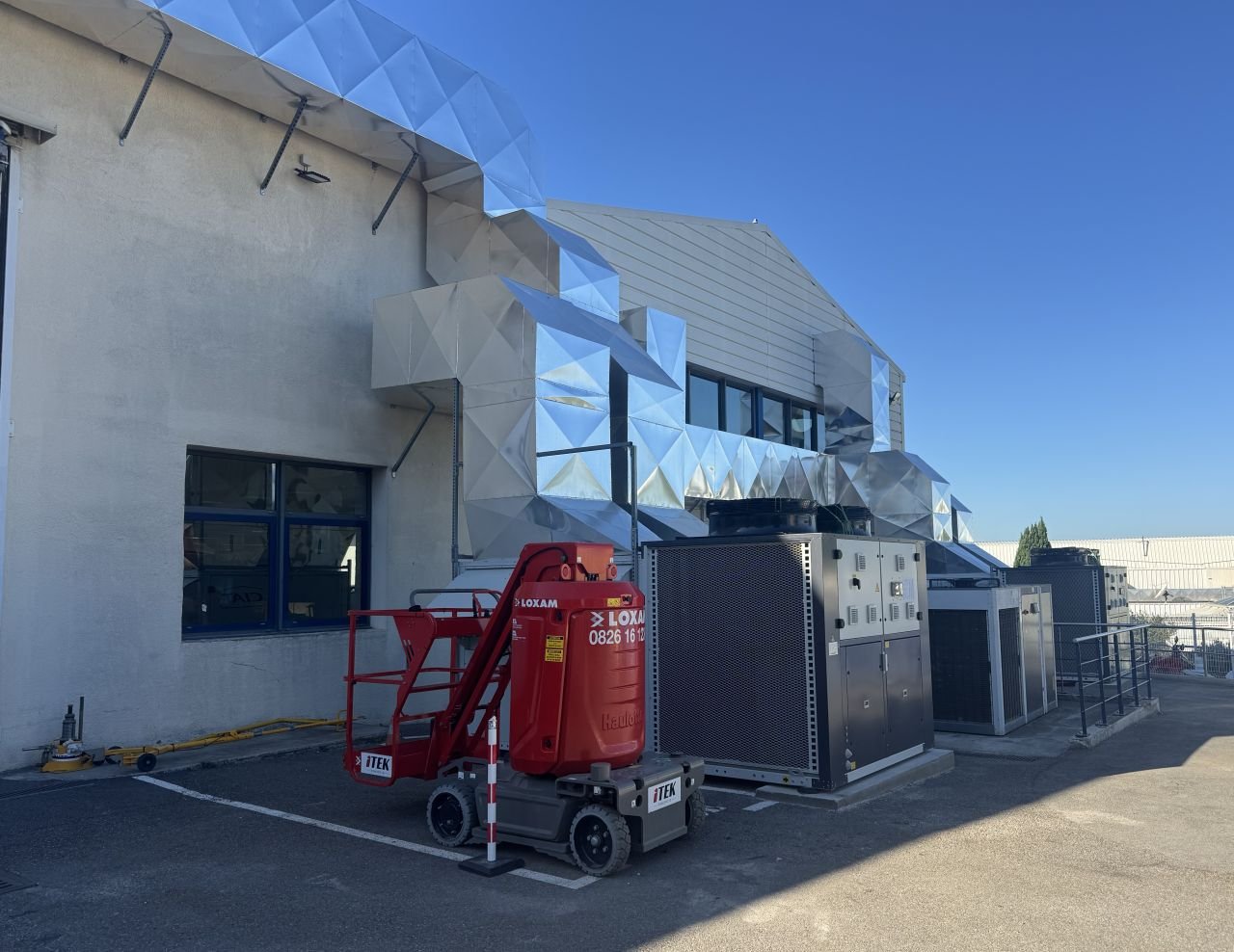 Équipements CVC et nacelle de chantier sur le site industriel